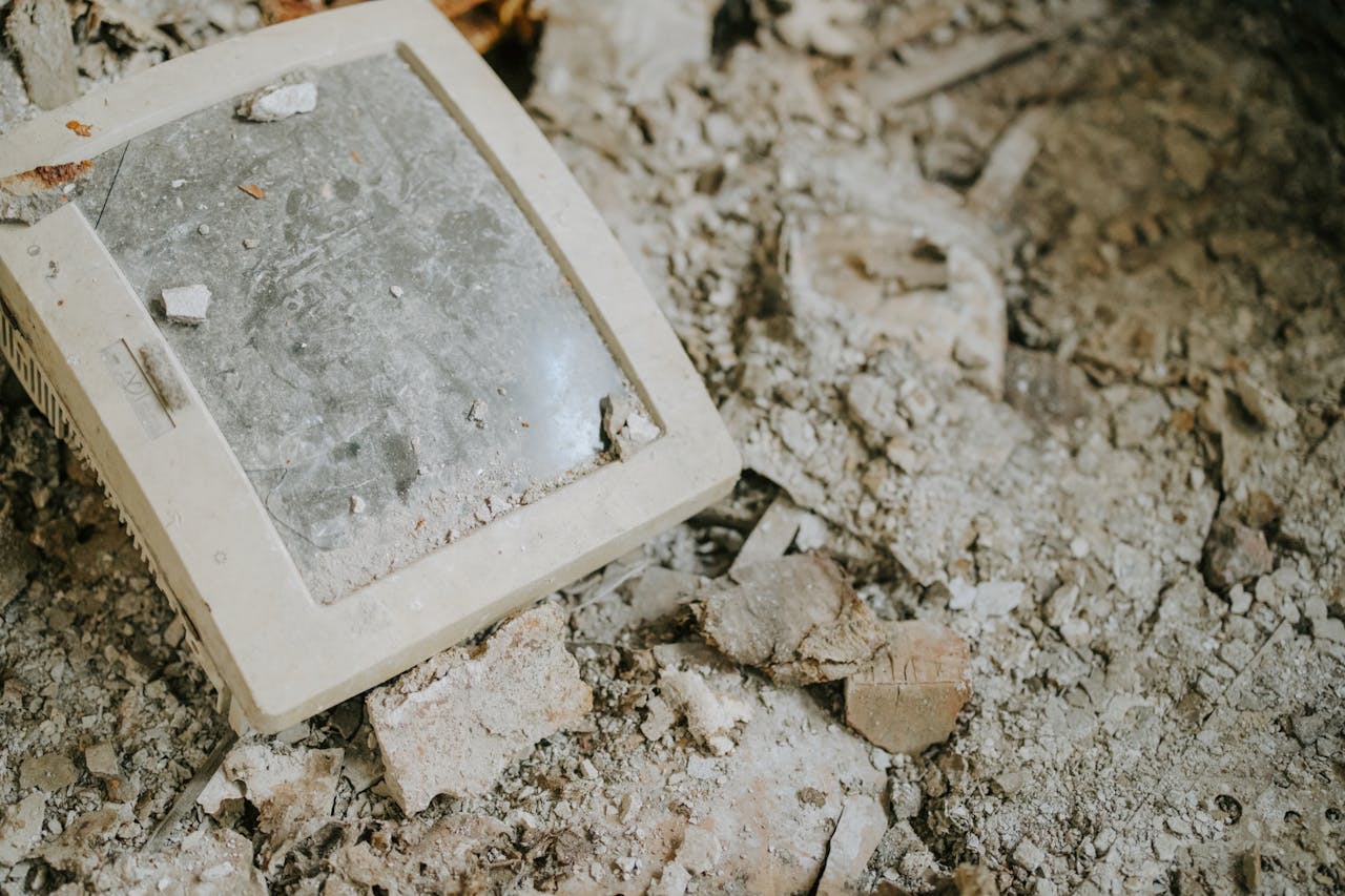 About An old monitor discarded on dusty, broken rubble, symbolizing decay and obsolescence.